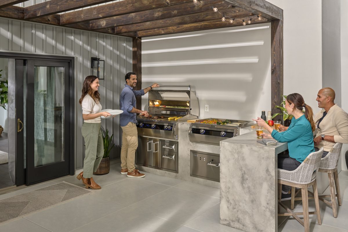Fire Magic outdoor kitchen island with a built-in grill and griddle and bar seating