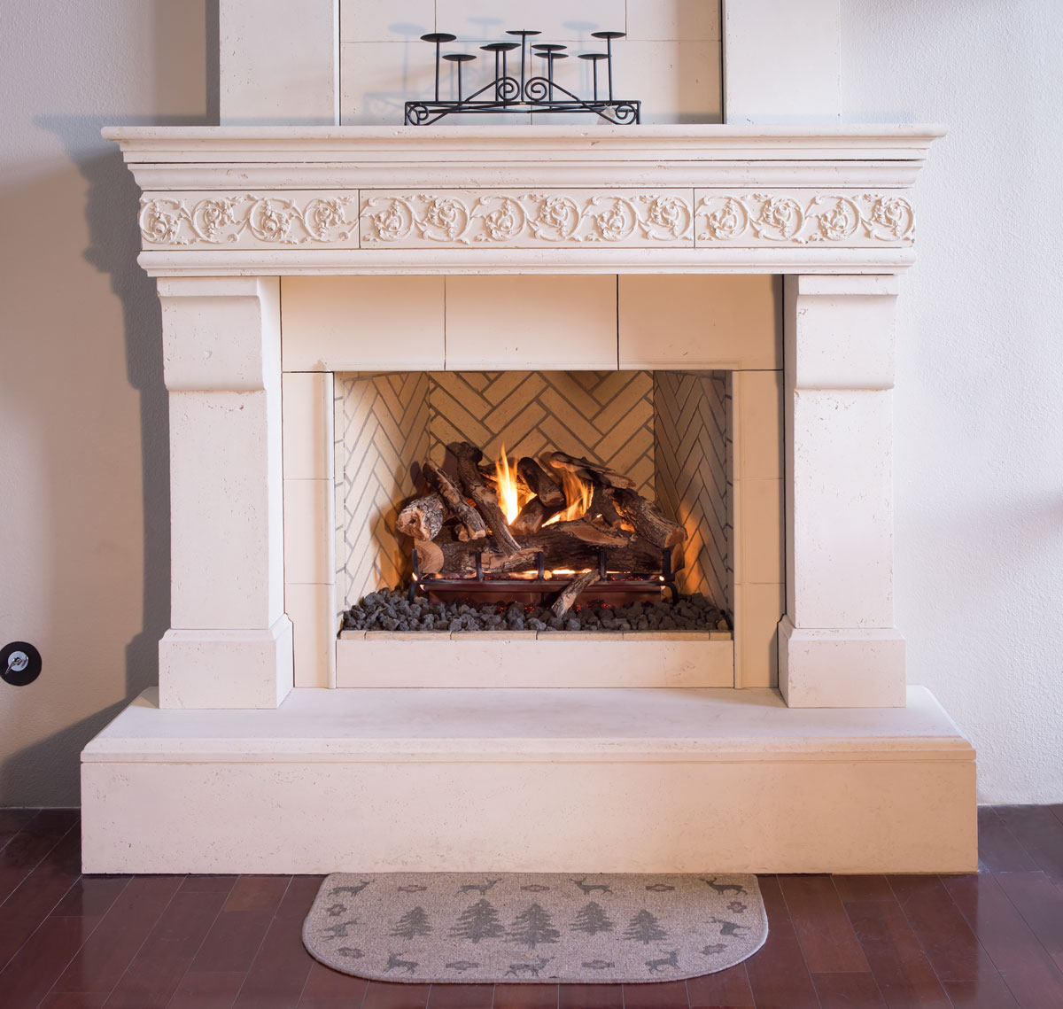 Grand Canyon weathered oak gas logs in a carved stone fireplace with herringbone firebox