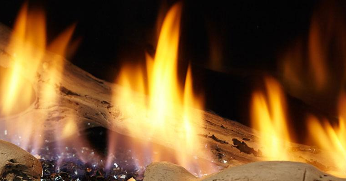 Close-up of Majestic gas logs with yellow flames over glowing embers