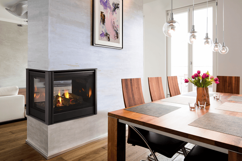 Majestic see-through gas fireplace in a plastered masonry wall beside a dining table