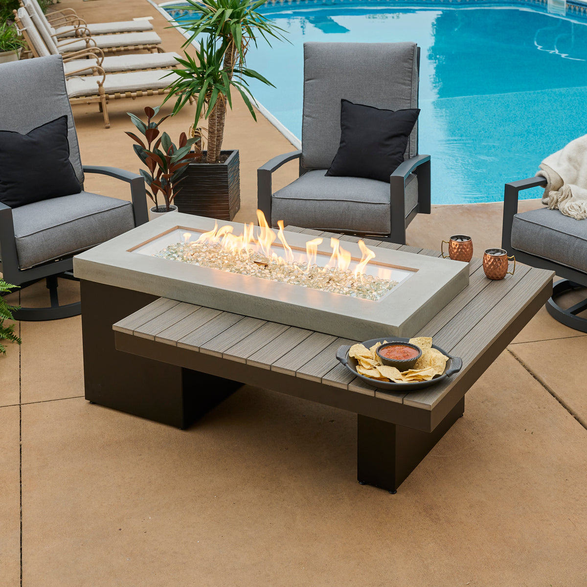 Outdoor Greatroom rectangular gas fire table with a linear flame and seating around it