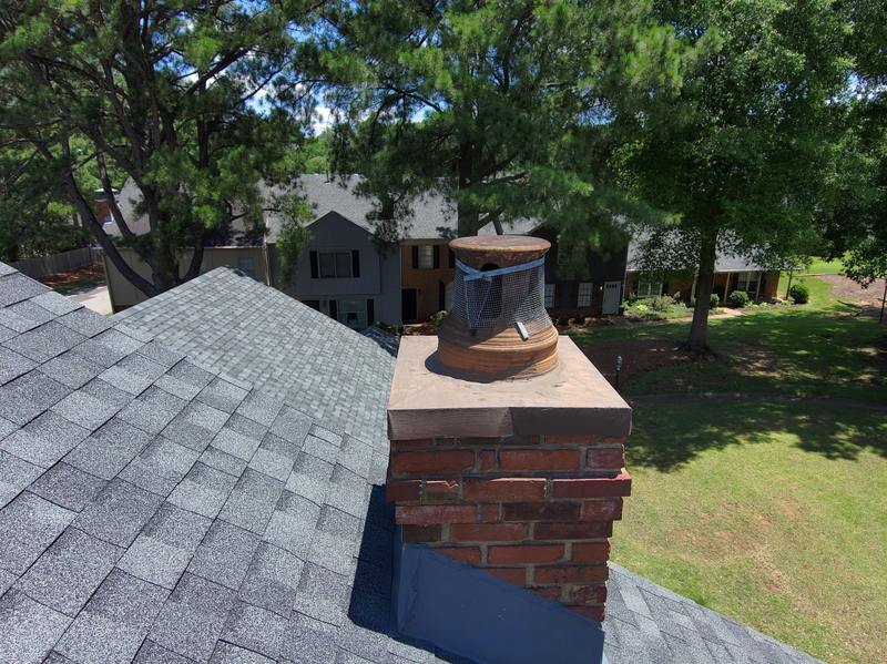 Chimney with worn crown under a clay pot and wire mesh before Madewell poured a new crown in Memphis