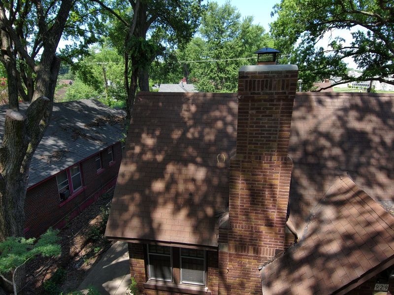 Drone view of a completed chimney rebuild on a Memphis home showing clean brickwork, new crown and cap and a tidy roofline