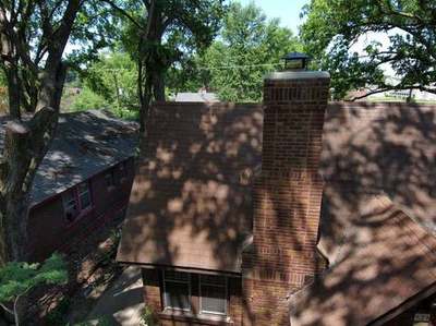 Drone view of a completed chimney rebuild on a Memphis home showing clean brickwork, new crown and cap and a tidy roofline