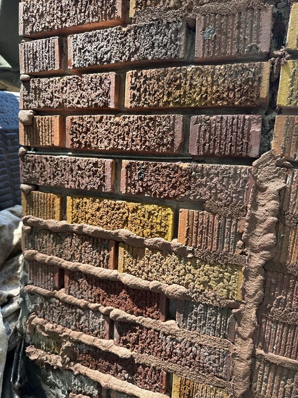 Chimney face with mortar joints ground out to full depth, steel reinforcement wire laid in the open joints and fresh mortar tucked over it during Madewell tuckpointing