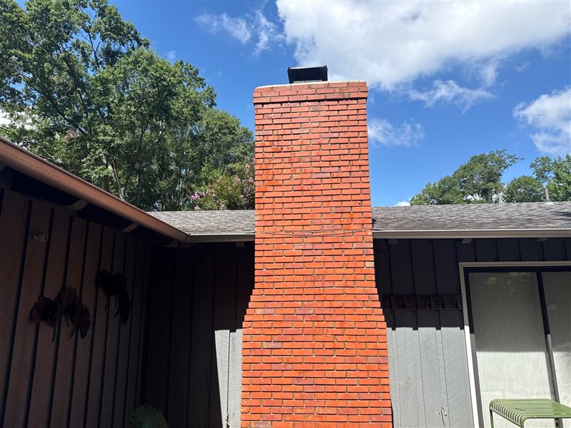 Tall red brick exterior chimney stack with clean joints and cap after Madewell rebuild in Memphis