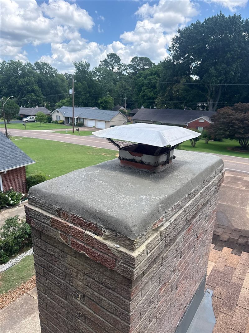 Fresh poured concrete chimney crown with stainless spark-arrestor cap after Madewell masonry repair in Memphis