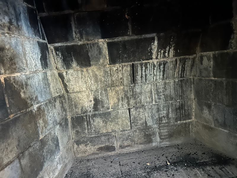 Failed wood-burning firebox with sooted, cracked firebrick and washed-out joints before Madewell rebuild in Memphis
