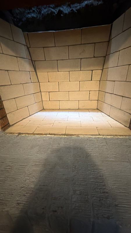 Rebuilt wood-burning firebox lined in new cream firebrick with tight refractory mortar joints by Madewell Masonry in Memphis