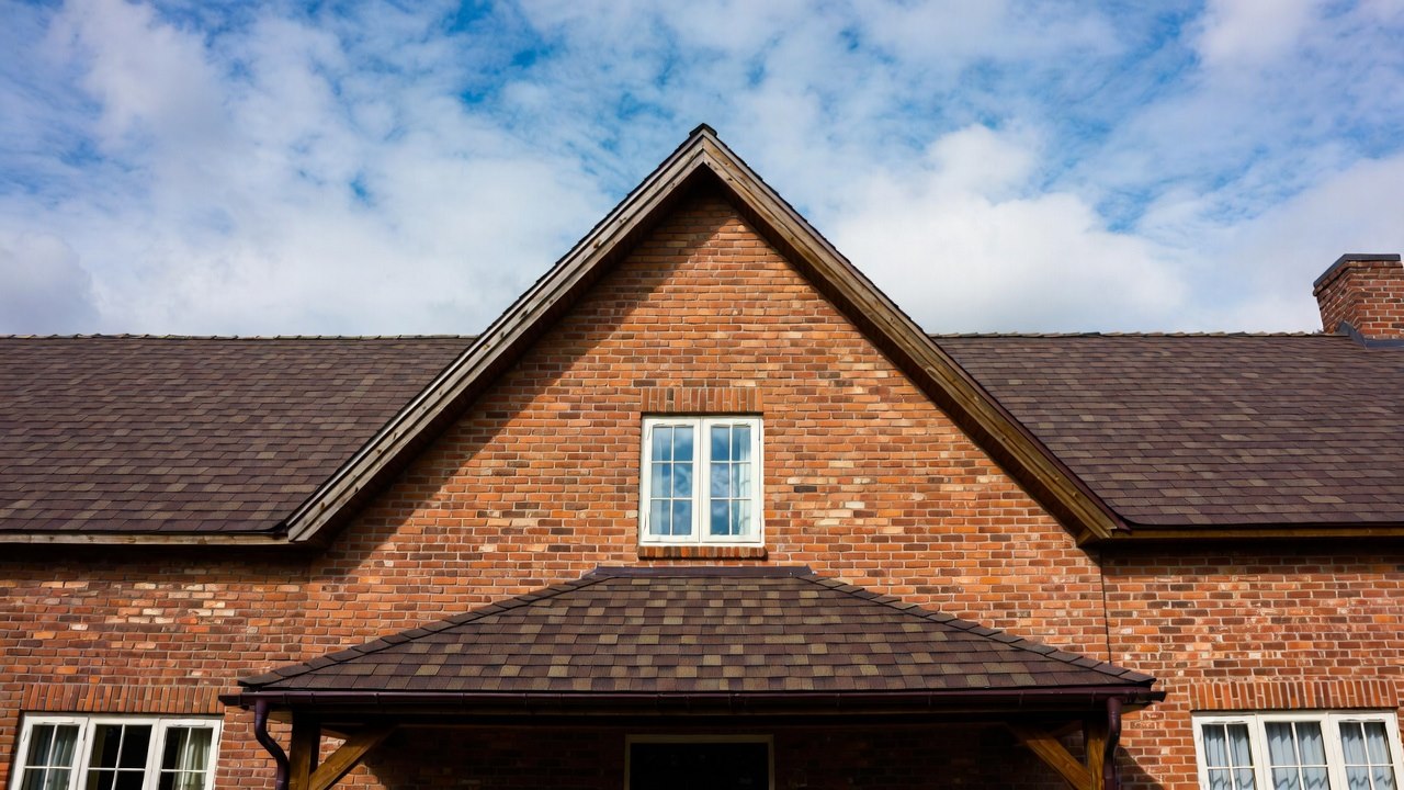 Red brick gable end with centered window under a peaked roof on a Memphis-area home