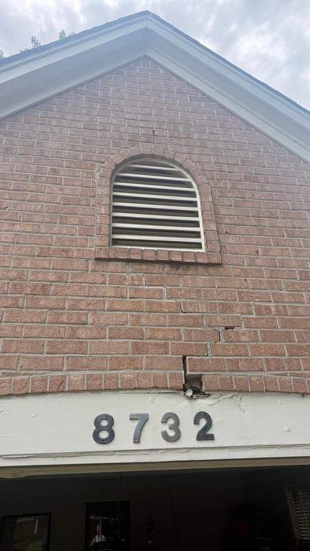 Cracked, sagging brick above a garage door before lintel repair in Memphis