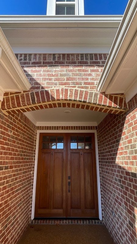 Rebuilt brick arch above a front entry double door with clean mortar joints after Madewell repair in Memphis