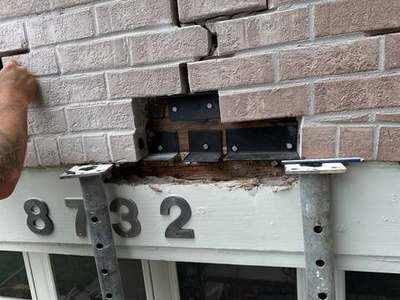 Close-up of a seismic bolt and steel plate securing a garage lintel to the structure on a Madewell job