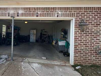 Steel shoring post supporting a garage door opening during lintel repair with the brick course above opened up