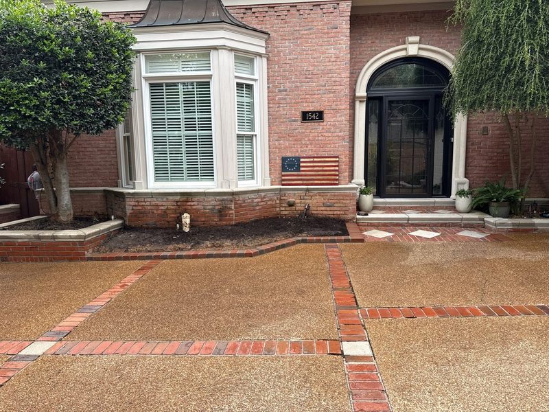Same front-yard masonry bed after Madewell renovation with brick curb and finished look