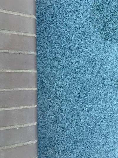 Close view of brick pool coping with fresh mortar joints packed full and struck flush, beside the blue water of the pool
