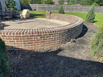 Curved brick patio retaining wall with fresh color-matched tuckpointing by Madewell Masonry in Memphis