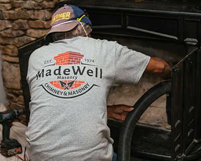 Technician inspecting fireplace - Madewell Masonry2