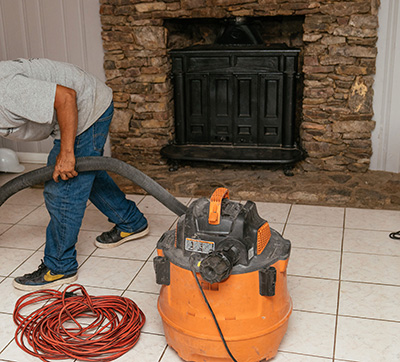 Technician vaccuming around the fireplace - Madewell Masonry