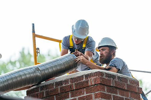 Techs looking at new chimney liner - Madewell Masonry