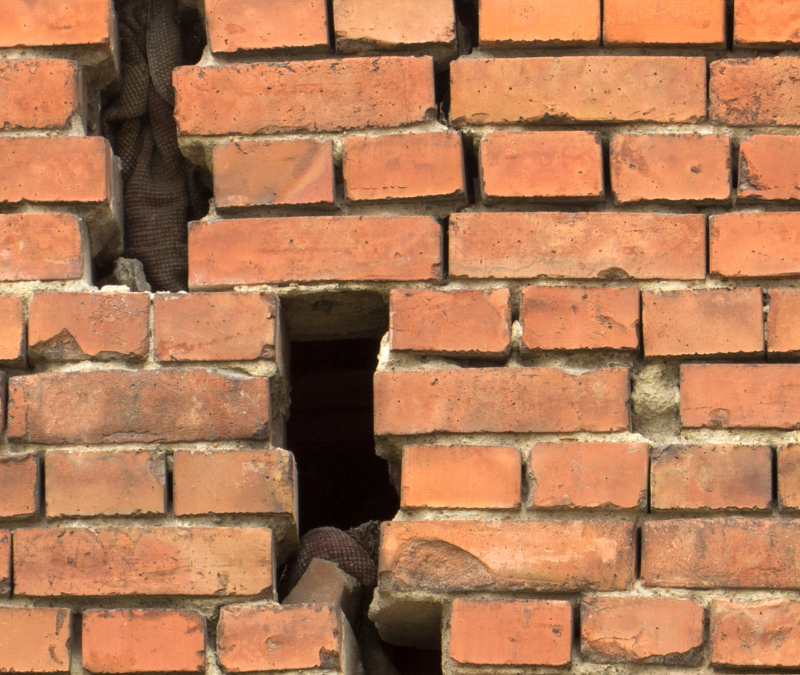 a masonry wall that is severely cracked and deteriorated