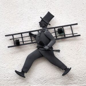 a metal chimney sweep figurine with a ladder, brushes, and top hat