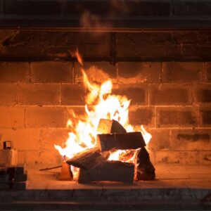 a fire burning in a brick fireplace firebox